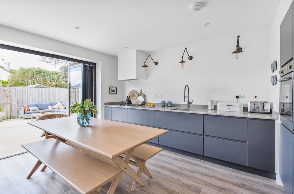 Open plan dining area and kitchen with full width bifold doors onto the patio garden