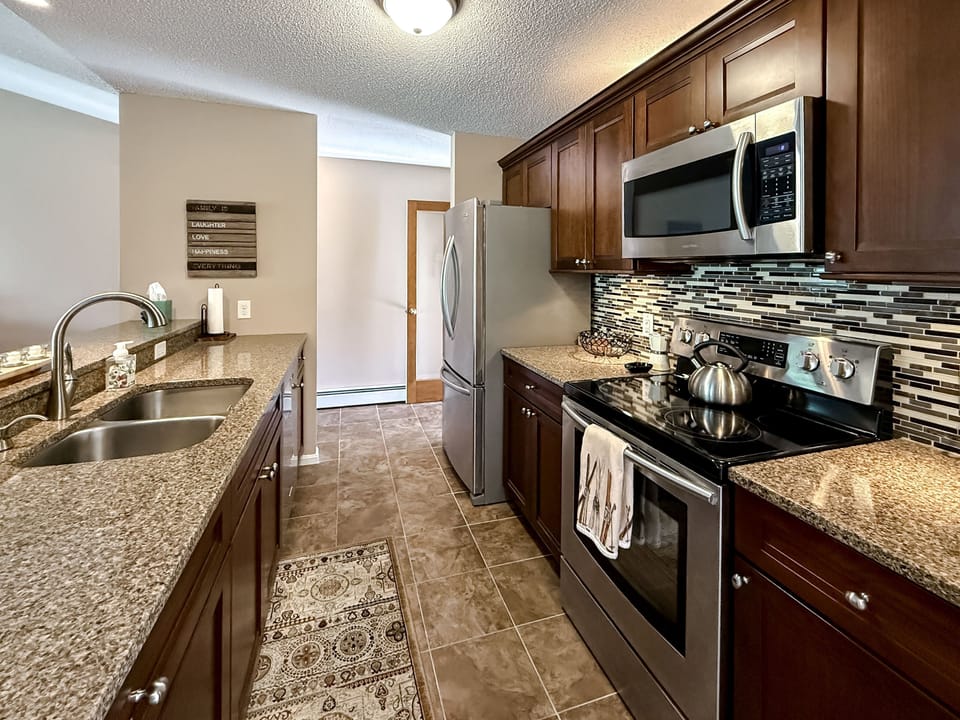 Another detail of the kitchen. Notice the beautiful countertops and stylish backsplash. Modern appliances!
