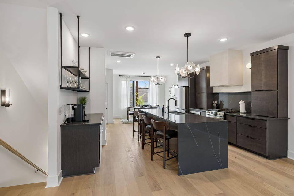 Kitchen: A stylish kitchen with an island, bar seating, and contemporary lighting.