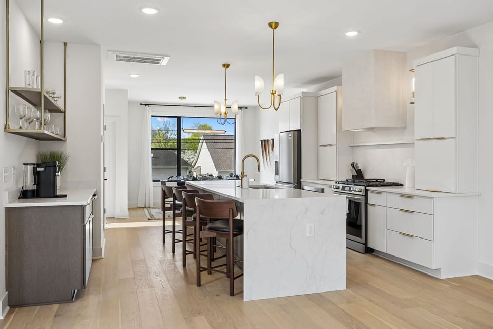 Kitchen: A spacious kitchen featuring a large island, bar stools, and pendant lights above.