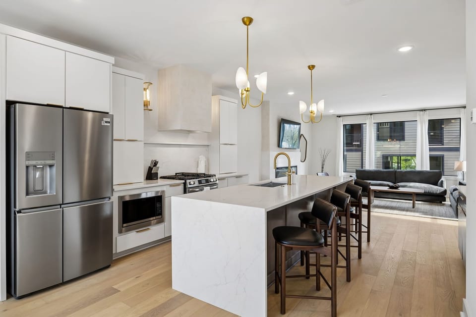 Kitchen: A spacious kitchen featuring a large island, bar stools, and pendant lights above.