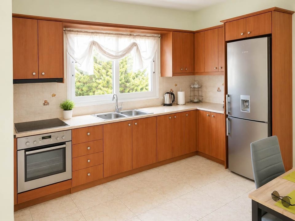 Fully equipped kitchen with modern appliances, spacious countertops, and dining area, ideal for preparing meals during short or longer stays in Salamina.