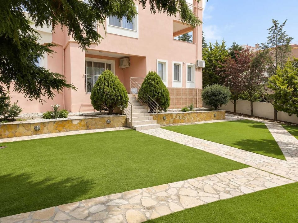 Shared garden and exterior entrance of the building surrounded by greenery, offering a peaceful outdoor setting just minutes from Salamina Marina and nearby beaches.