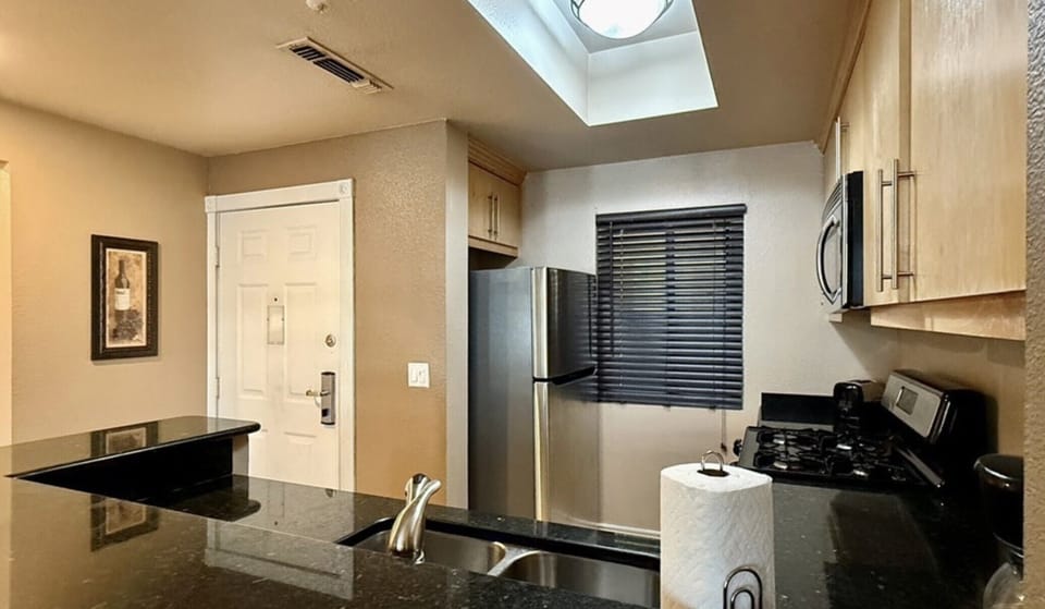 Fully equipped kitchen with pots, pans, dishes, and utensils.