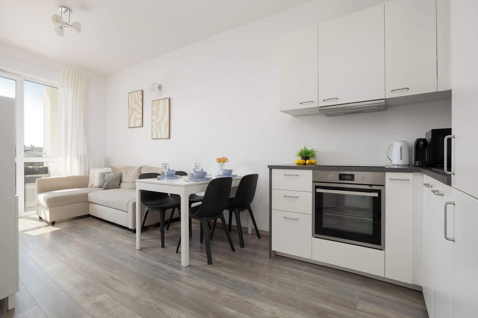 A modern kitchen with white cabinets, an oven, and built-in appliances. The space is clean and functional, designed for easy cooking.
