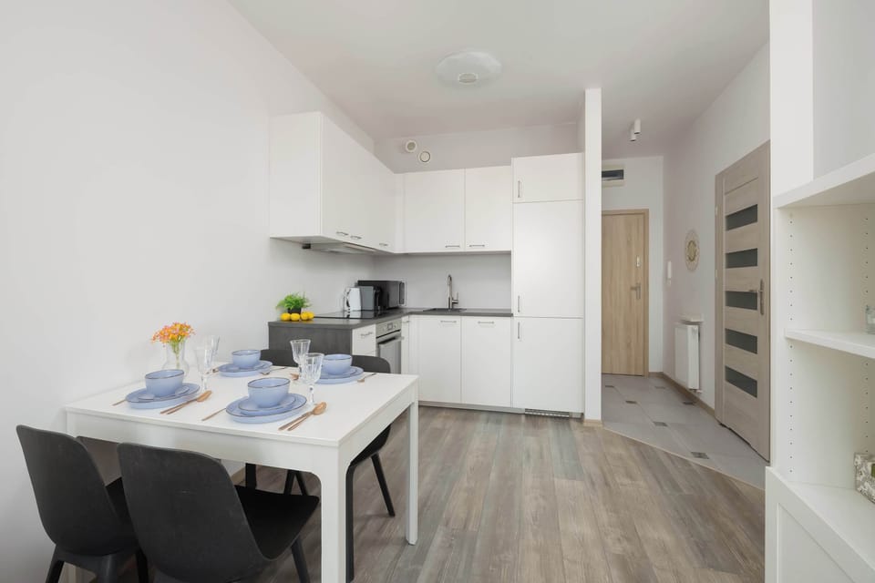 A dining table set in a bright open-plan living area. The space is designed for comfortable meals and social moments.