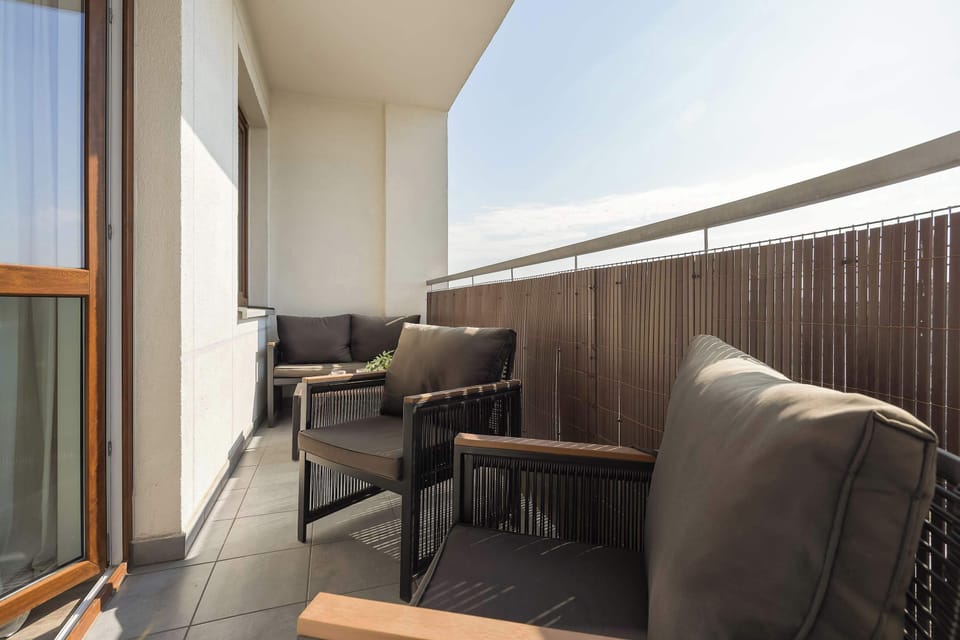 A balcony seating area with chairs overlooking the neighborhood. It provides a quiet outdoor spot to enjoy the surroundings.