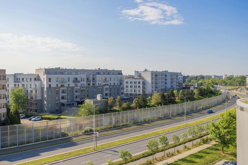 A roadway and river view stretching through the city landscape. The perspective shows open space and urban infrastructure.