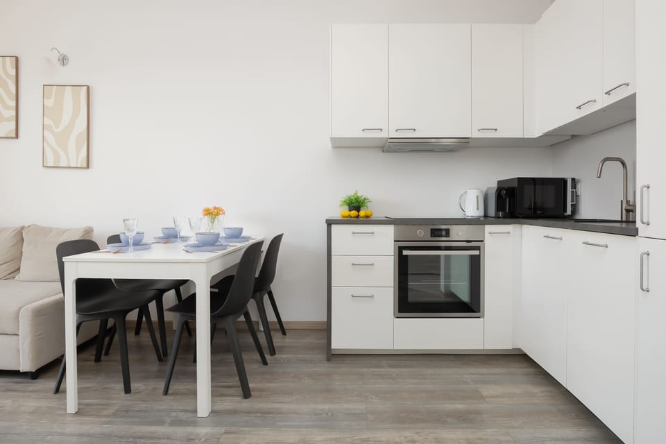 A compact kitchenette with modern cabinets and integrated appliances. The design is functional and clean, offering everything needed for convenient cooking.