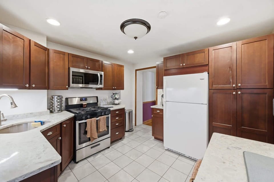 Well-equipped kitchen w/ wood cabinetry, stainless appliances & fridge freezer.