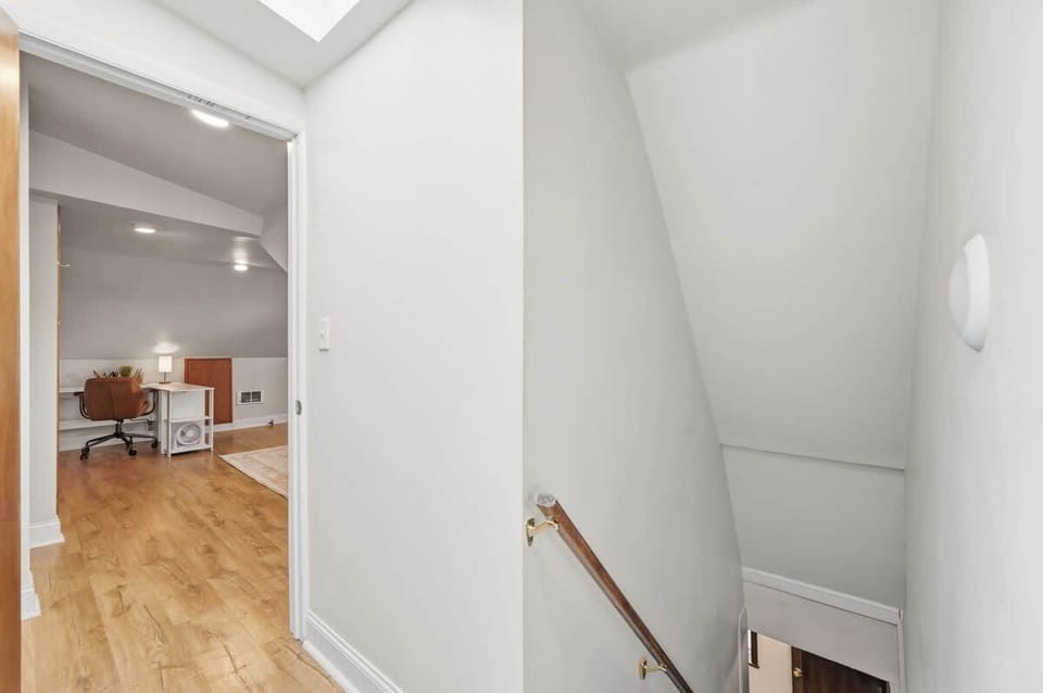 Open hallway view w/ wood floors flowing toward the staircase.