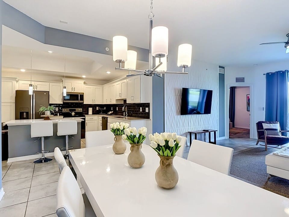 Modern open kitchen and dining space with breakfast bar and seamless living area connection.