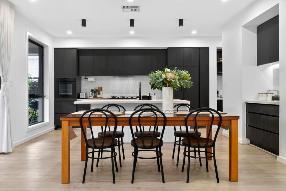 Open-plan kitchen & dining with dark cabinetry & island