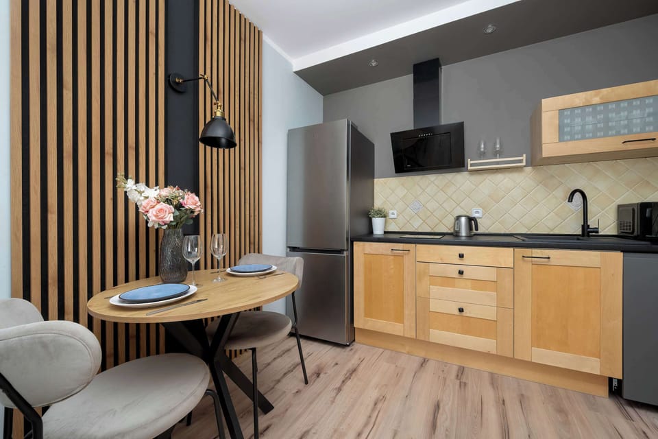Modern kitchenette with wooden cabinetry and black appliances