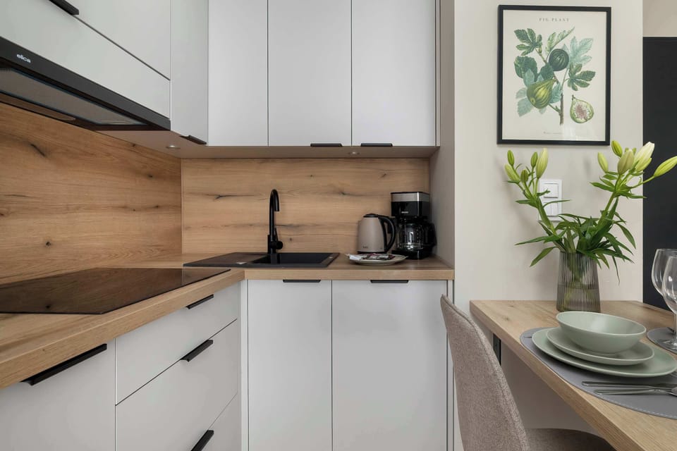 A close-up view of a modern kitchen with wooden countertops and white cabinets. The space looks clean, functional, and well-equipped for cooking.