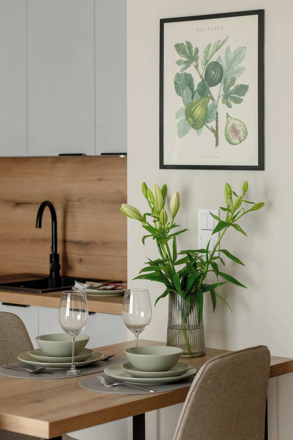 A close-up of a wooden dining table set in a stylish open-plan space. The arrangement highlights a warm and inviting place for shared meals.