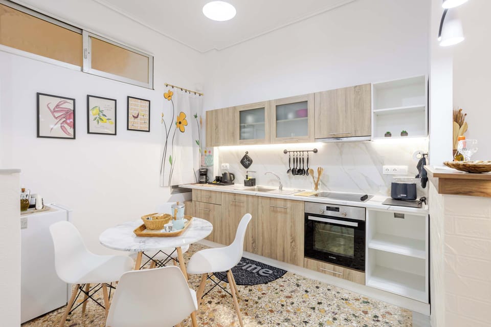 Fully equipped modern kitchen with sleek cabinetry, dining table, and everything needed for home cooking.