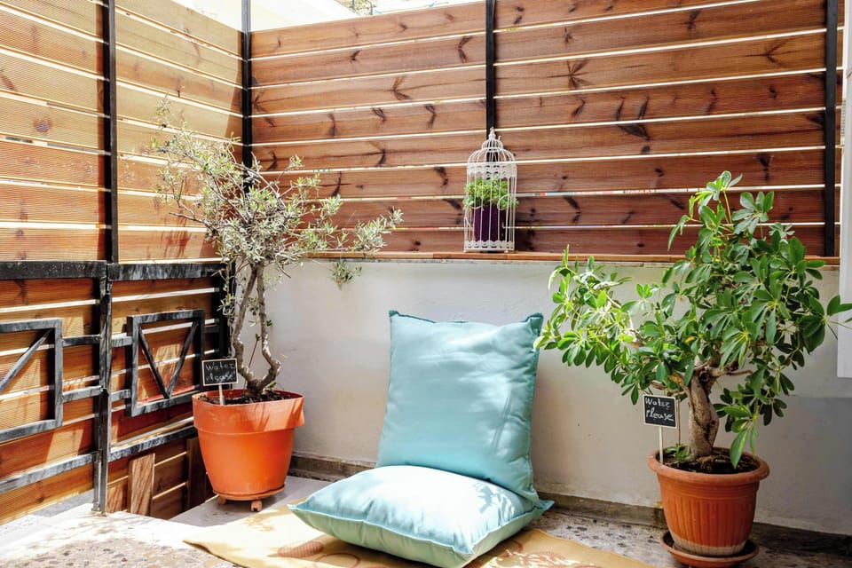 Tranquil patio corner with lush plants, privacy fencing, and comfortable lounge seating.