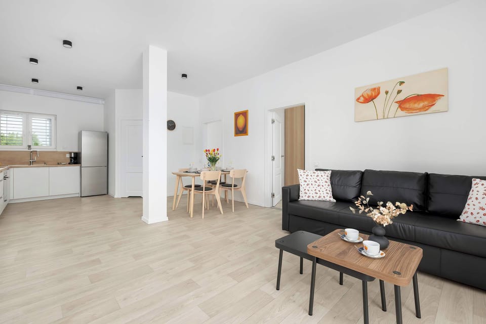A bright living and dining space with modern furniture. Light flooring adds to the spacious feeling.