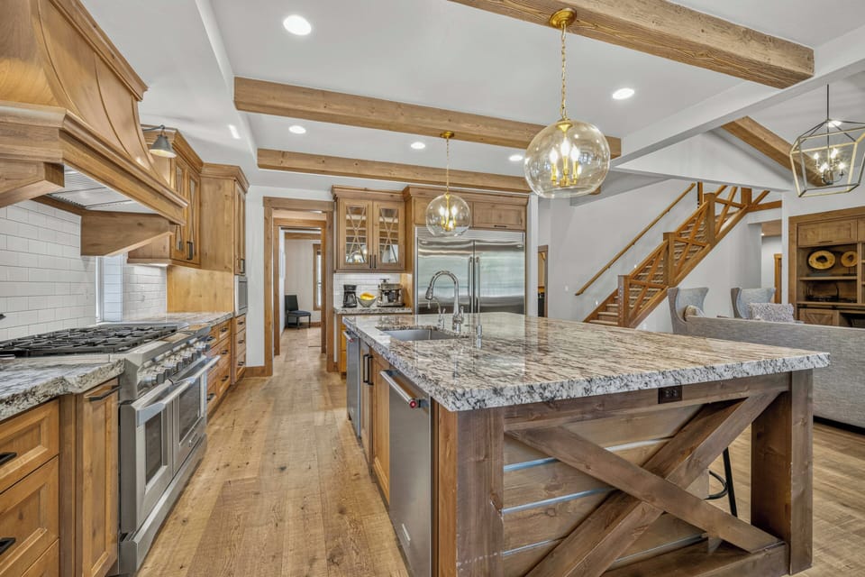 Your gourmet kitchen awaits with granite countertops, premium appliances, and rustic wood beams overhead—perfect for preparing memorable meals during your stay.
