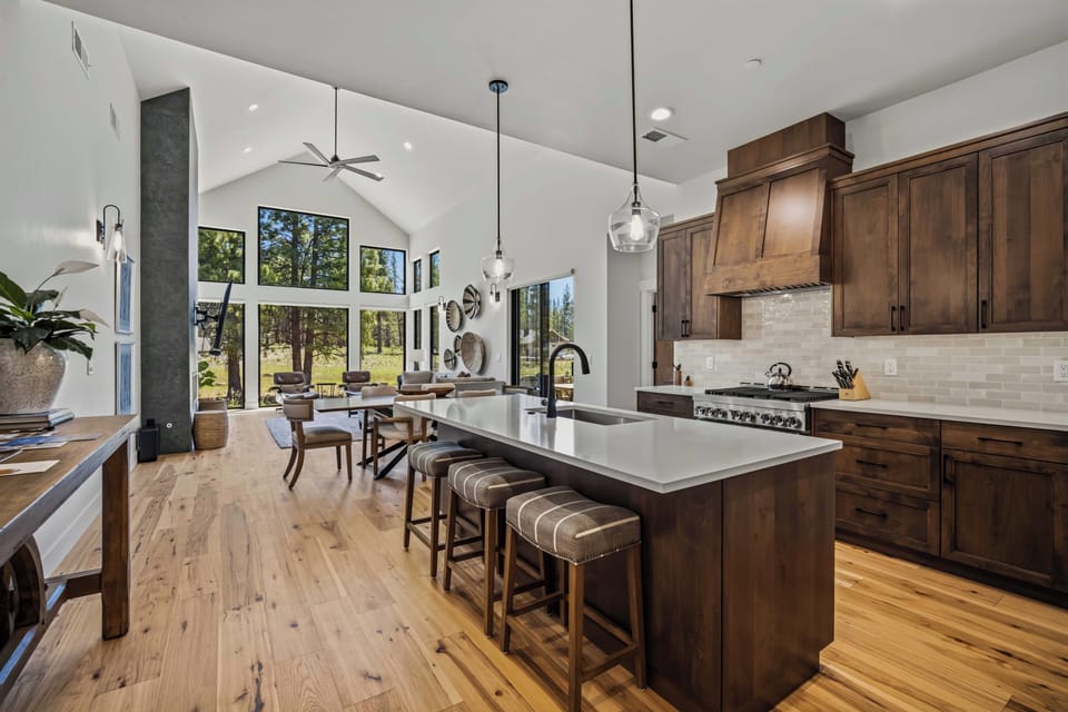 Gather in this stunning open-concept kitchen where soaring ceilings and natural light create an inviting atmosphere for cooking and conversation. You'll love the spacious island and rich wood cabinetry framing your culinary adventures.