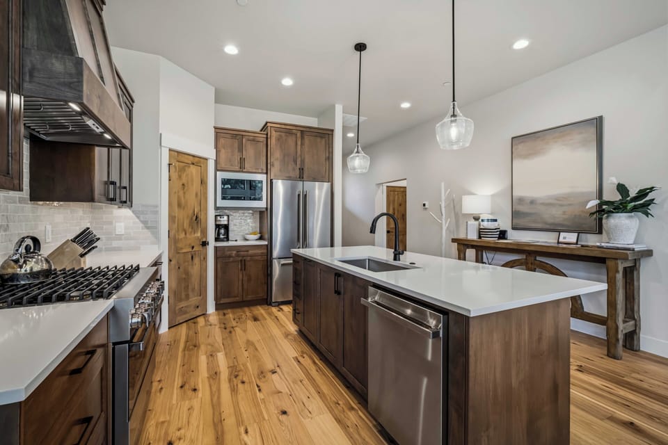 Picture yourself cooking in this spacious, modern kitchen with warm wood cabinetry, stainless appliances, and a central island perfect for meal prep or casual dining.