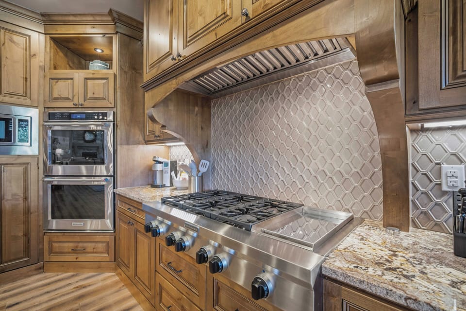 Step into your gourmet kitchen, where professional-grade appliances and elegant cabinetry create your perfect culinary retreat, ready for your mountain getaway meals.