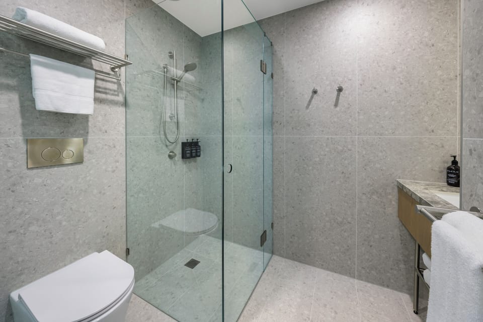 Brady King Skyline | Bathroom | Shower, hair dryer, slippers, towels