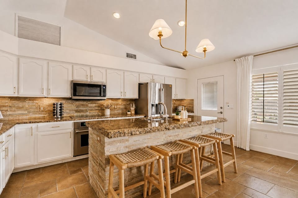 A warm, spacious kitchen with generous island seating—perfect for prepping meals, pouring drinks, and staying connected.