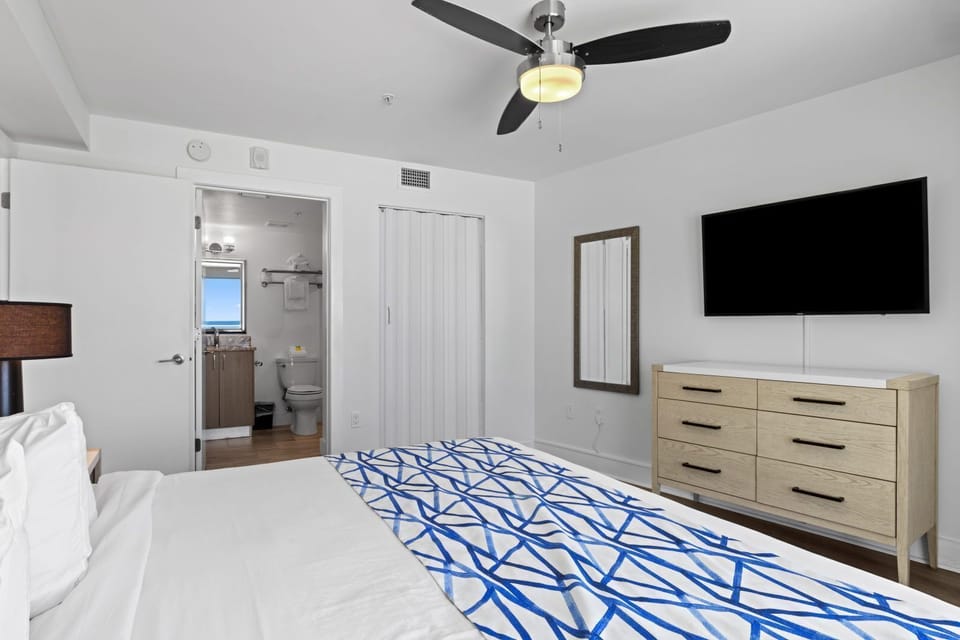 Relax in a cozy bedroom featuring a king bed, stylish decor, and a flat-screen TV.