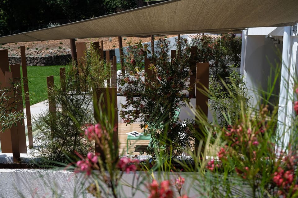 Garden-level terrace glimpsed through wooden partitions — private and sheltered by foliage