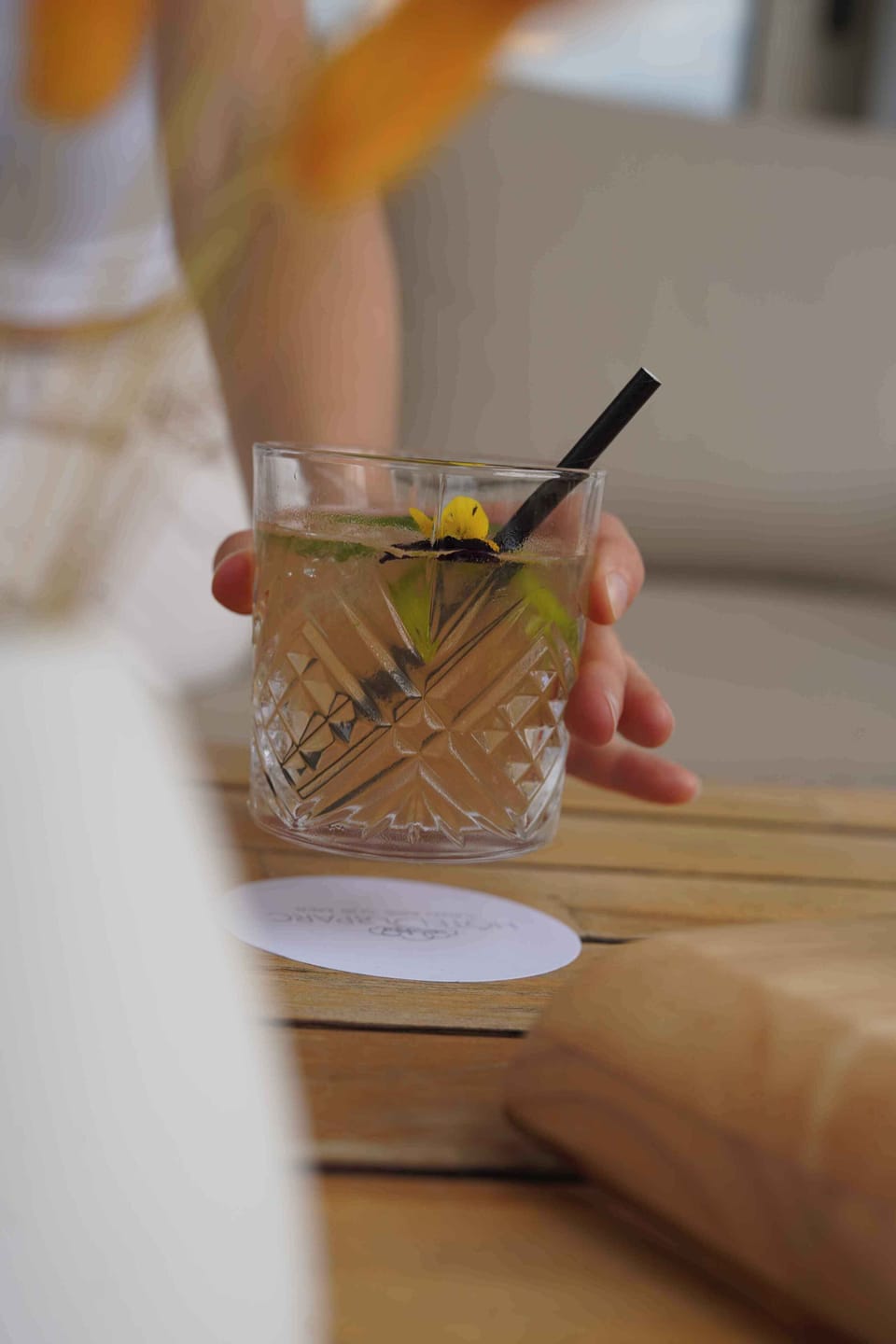 A floral-garnished cocktail served at one of the outdoor terrace tables