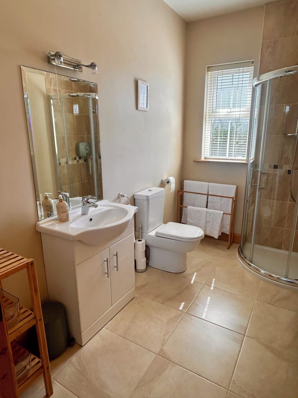 Spacious bathroom with walk in power shower & vanity unit with basic toiletries
