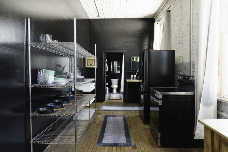 Kitchen has electric stove, fridge and pots/pans  for cooking