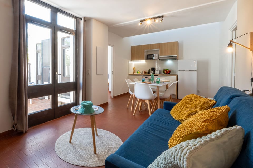 Bright and open living area with sofa bed — air conditioned and designed for comfortable coastal living.