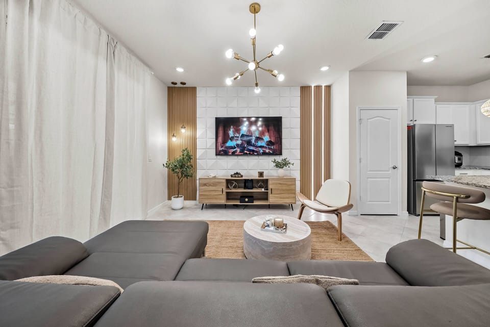 Relax in the stylish living area with plush sectional seating and a sleek coffee table. The warm wood accents and soft lighting create a cozy ambiance, ideal for unwinding after a day full of adventure and exploration.