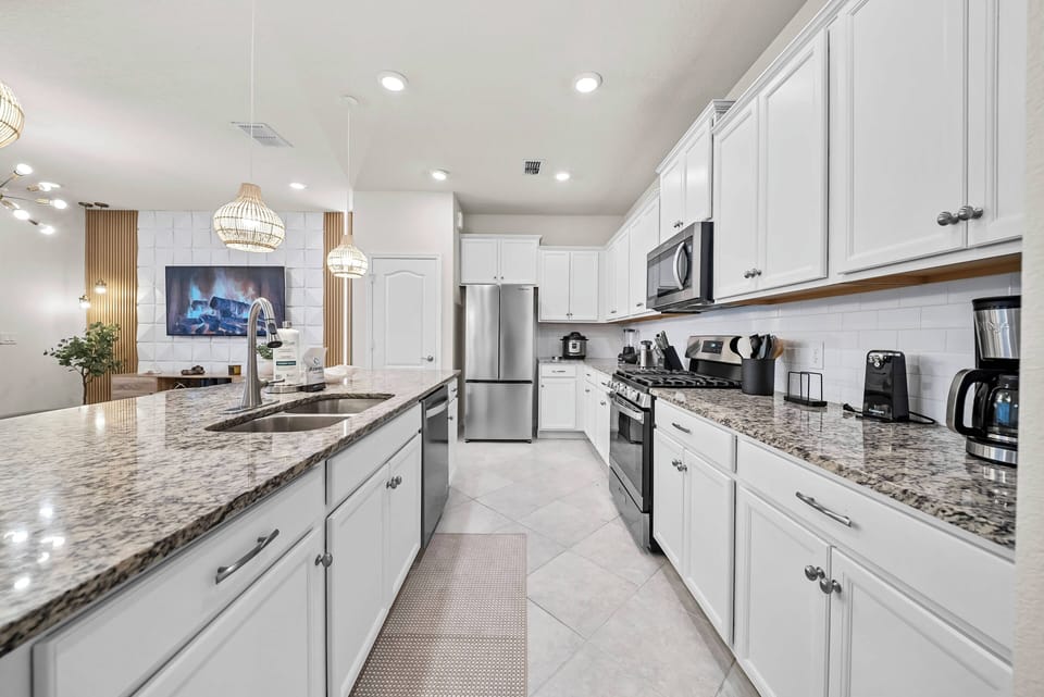 Experience a stunning kitchen with sleek white cabinetry and elegant granite countertops that inspire your culinary creativity.