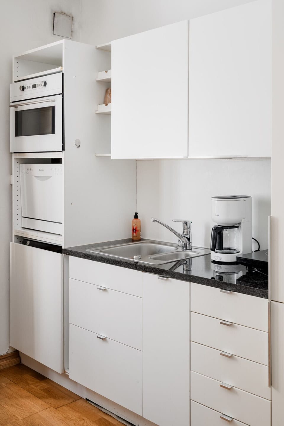 The modern kitchenette is fully equipped with a dishwasher and integrated appliances, making long-term stays or quick meals a breeze.