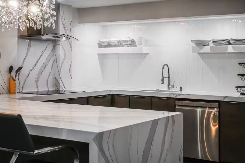 Designer kitchen with waterfall island, dishwasher & fully stocked essentials.