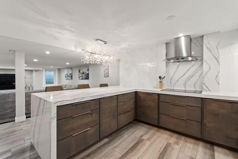 Modern full kitchen with quartz countertops, waterfall island & ample storage.