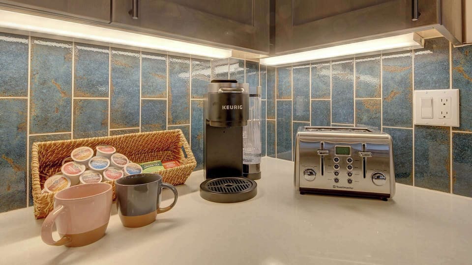 Kitchen supplies & small appliances included: Keurig, coffee pods, tea, drip coffee maker, coffee grinder, toaster, griddle, waffle iron, crock pot, blender, salt, pepper, olive oil, and assortment of spices.