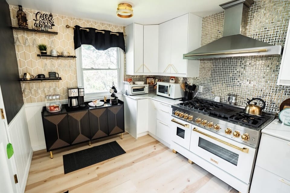 A stunning white double-oven gas range features a sleek six-burner cooktop, striking gold hardware knobs, and a matching gold-trimmed handle.
