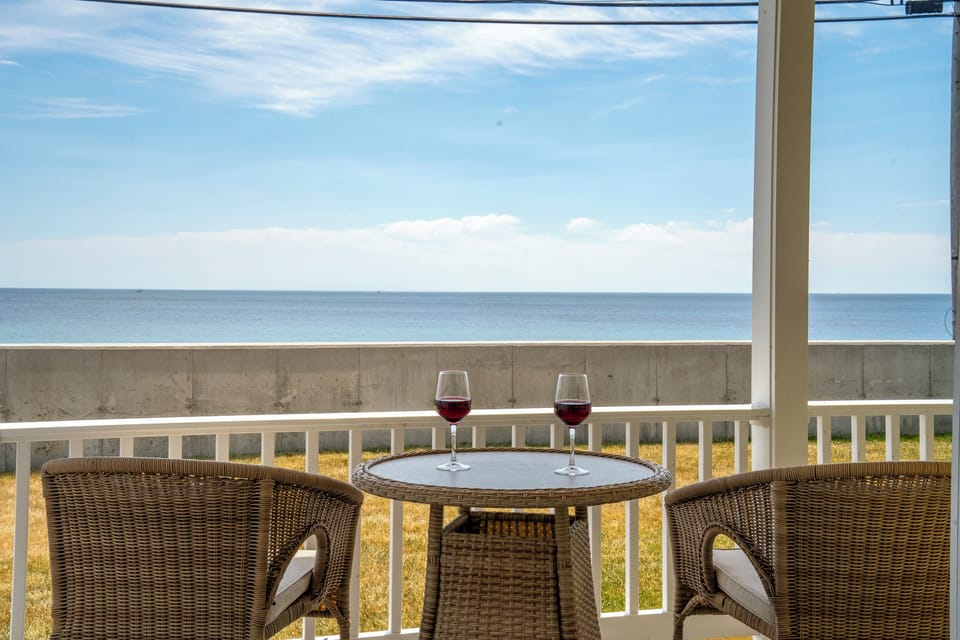 Covered oceanfront porch with panoramic water views