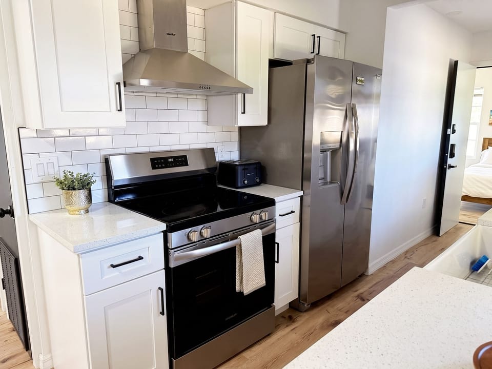 Kitchen with a stainless range, side-by-side fridge, and subway-tile backsplash