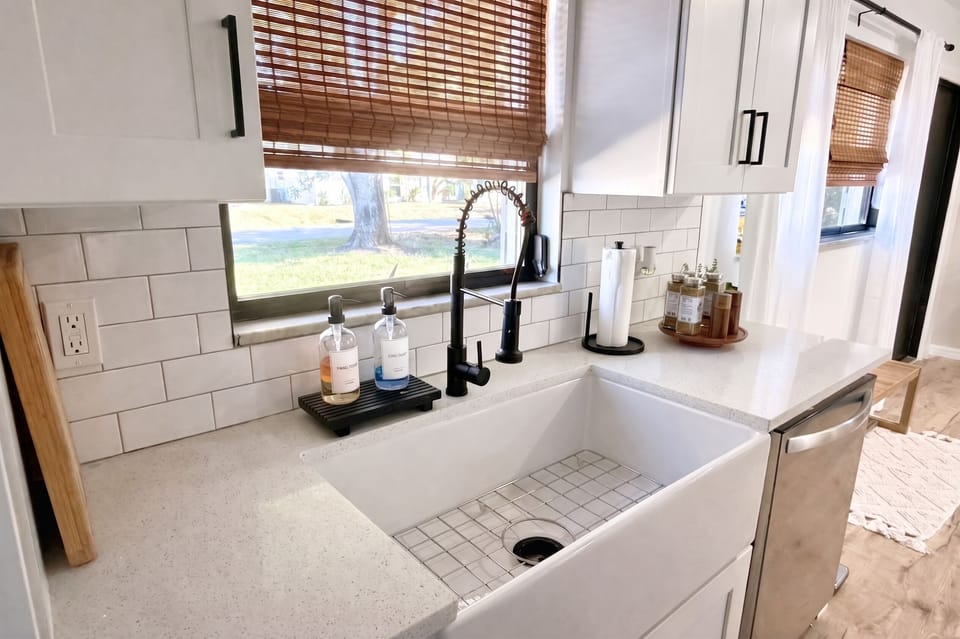 Farmhouse sink and subway tile with a window over the yard
