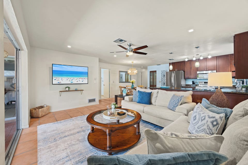 Cozy and inviting living room with seamless access to the covered outdoor lounge and pool area.
