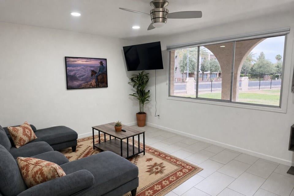 Open-concept living room with modern decor and Southwest cactus wall art