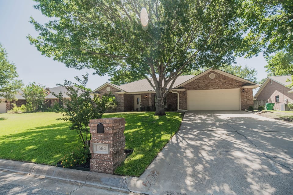 Charming brick home with spacious driveway and beautiful shaded front yard