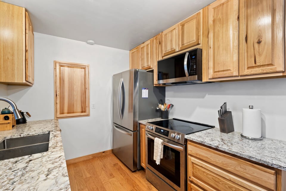 Features gas stove, microwave and refrigerator.