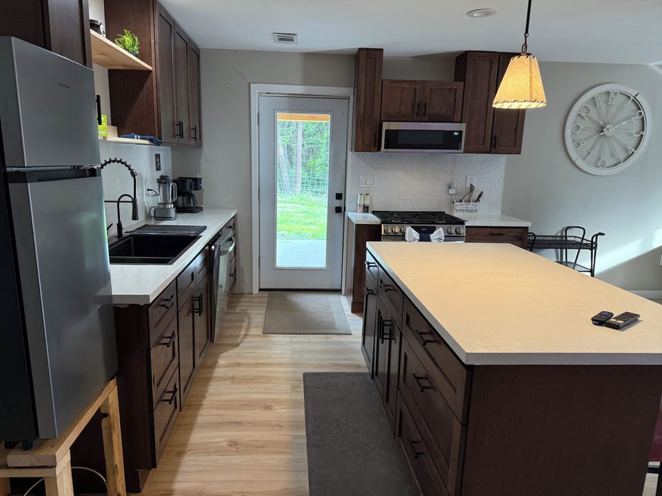 Modern kitchen with large island, stainless appliances, and outdoor access